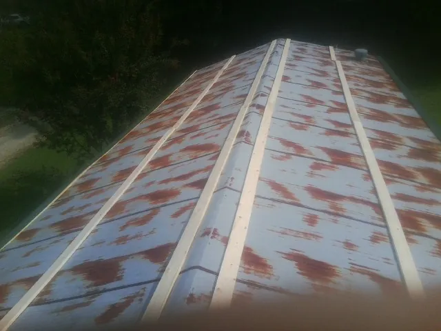 Rusted metal roof panels with new wood purlins before replacement — Storm Damage Roof Repair in Perry by Roofing Brothers